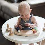Wooden infant activity center changes from a baby activity center to a toddler play table to a kid's table. Wooden design disassembles easily and stows neatly away until next time. This furniture piece is a beautiful addition to any modern nursery. Toys can be purchased to keep your little one entertained!